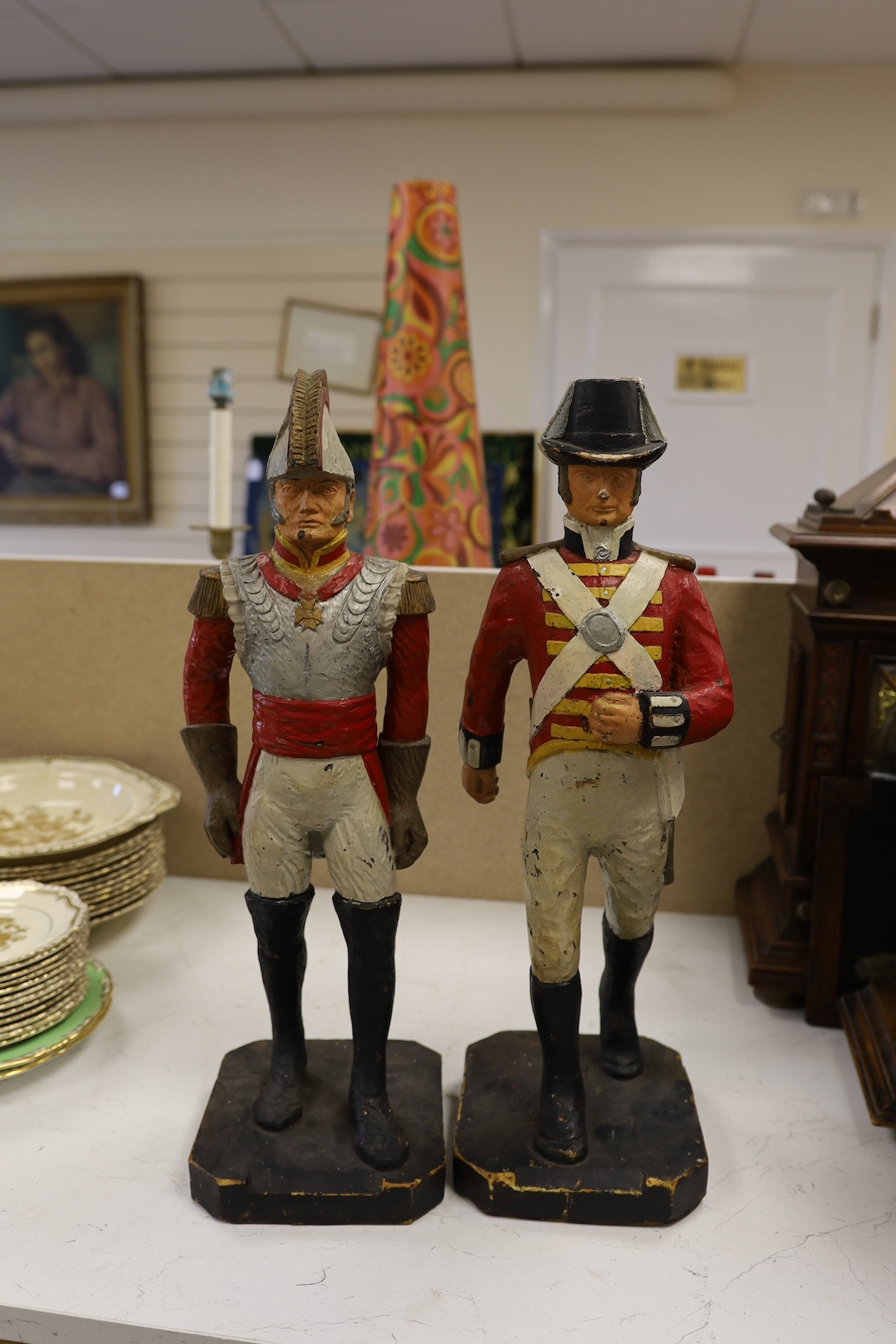 A pair of painted figures of soldiers in military dress, 49cm high. Condition - fair